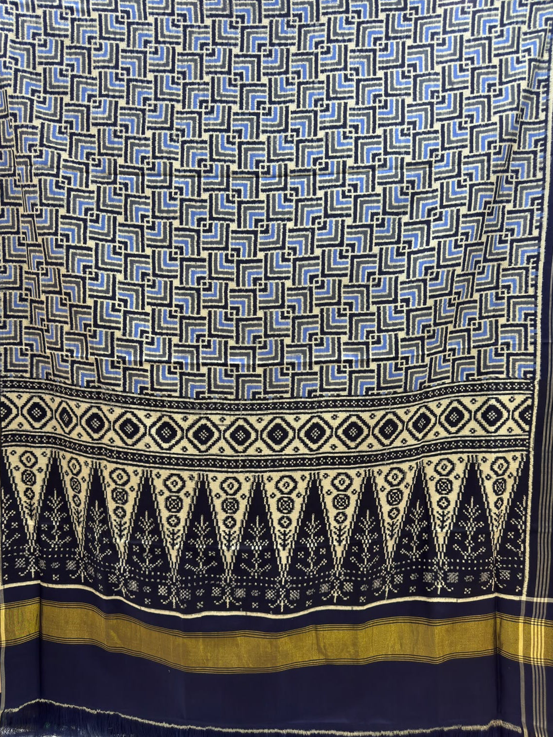 Black and blue Patan Patola pure mulberry silk saree featuring a geometric labyrinth pattern with a traditional black and cream patterned pallu.