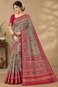 A striking green Patan Patola double ikat pure mulberry silk saree featuring intricate red and white geometric patterns, ornate contrasting borders, and a magnificent rich red pallu dyed using natural vegetable colors.