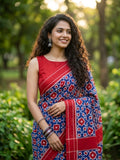 A luxurious red Pochampally handloom silk saree featuring intricate Teliya Rumal double ikat geometric patterns and a traditional border.