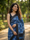 A luxurious red Pochampally handloom silk saree featuring intricate Teliya Rumal double ikat geometric patterns and a traditional border.