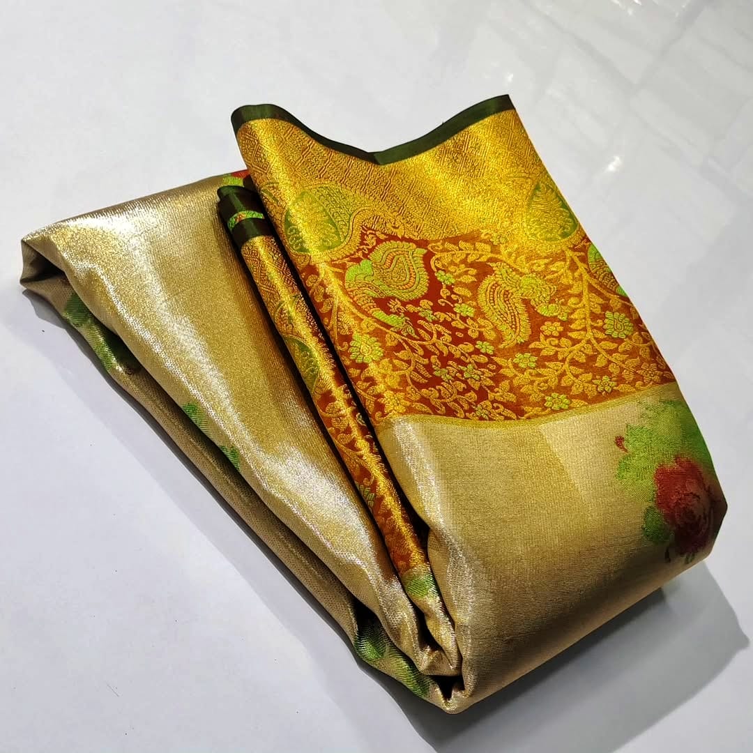 A close-up of a luxurious gold tissue Kanchipuram silk saree with vibrant rust orange borders and intricate Meenakari floral brocade weaving.