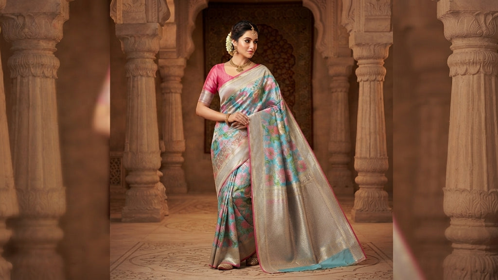 A woman wearing a luxurious turquoise Kanchipuram handloom tissue brocade Meenakari silk saree with intricate floral motifs and a pink contrast border.