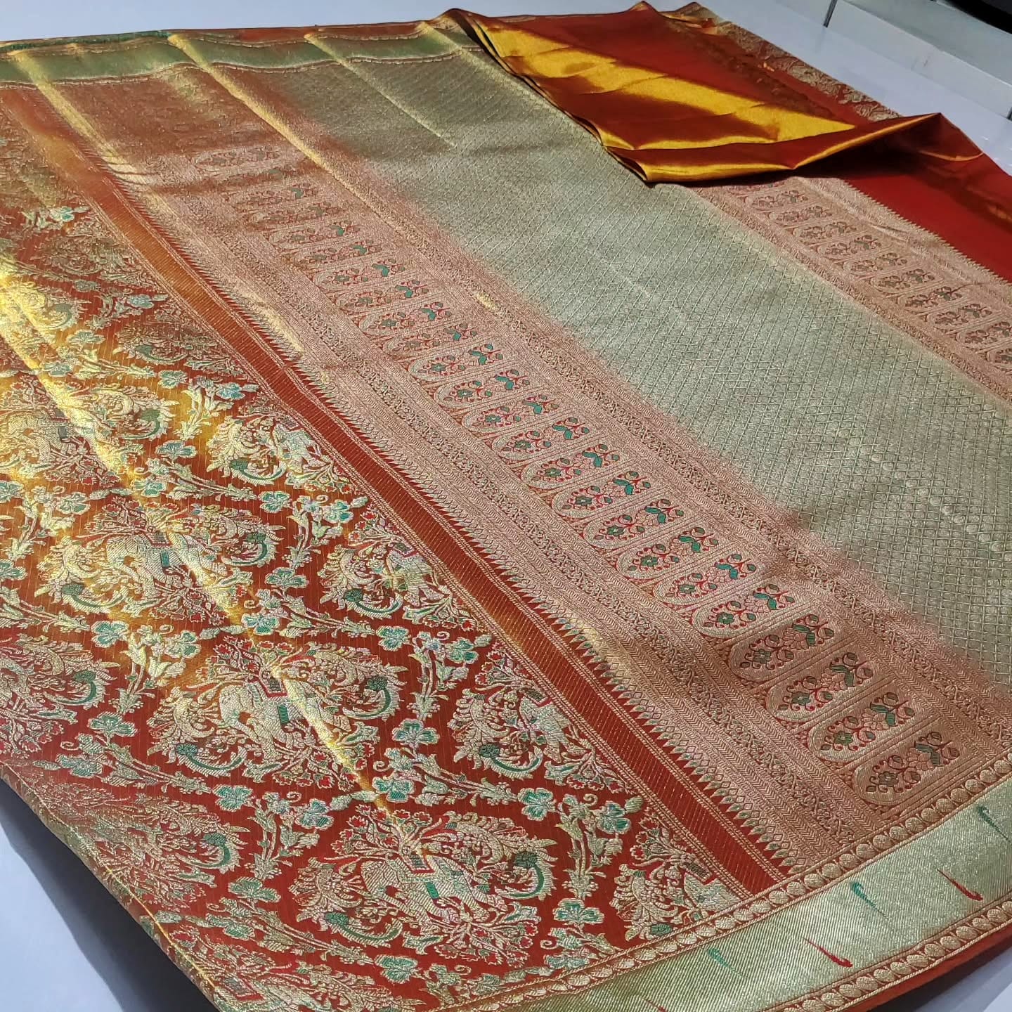 Exquisite coral Kanchipuram handloom tissue brocade Meenakari bridal saree with traditional Paithani borders.