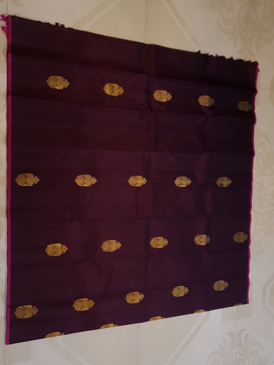 A certified magenta Kanchipuram handloom 3G pure gold borderless silk saree showcasing its rich color and lustrous weave.