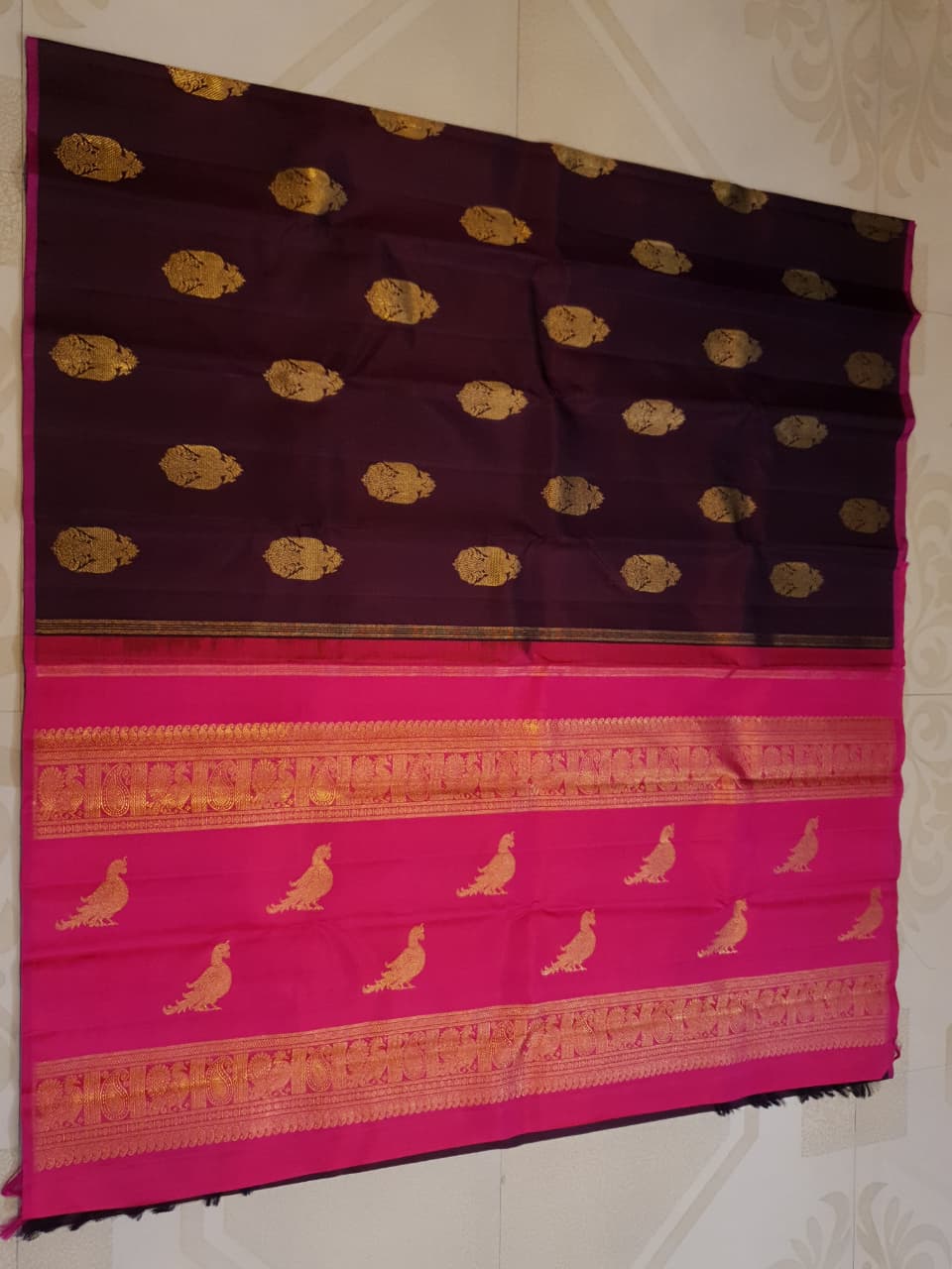 A certified magenta Kanchipuram handloom 3G pure gold borderless silk saree showcasing its rich color and lustrous weave.