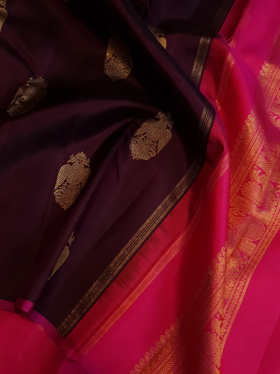A certified magenta Kanchipuram handloom 3G pure gold borderless silk saree showcasing its rich color and lustrous weave.