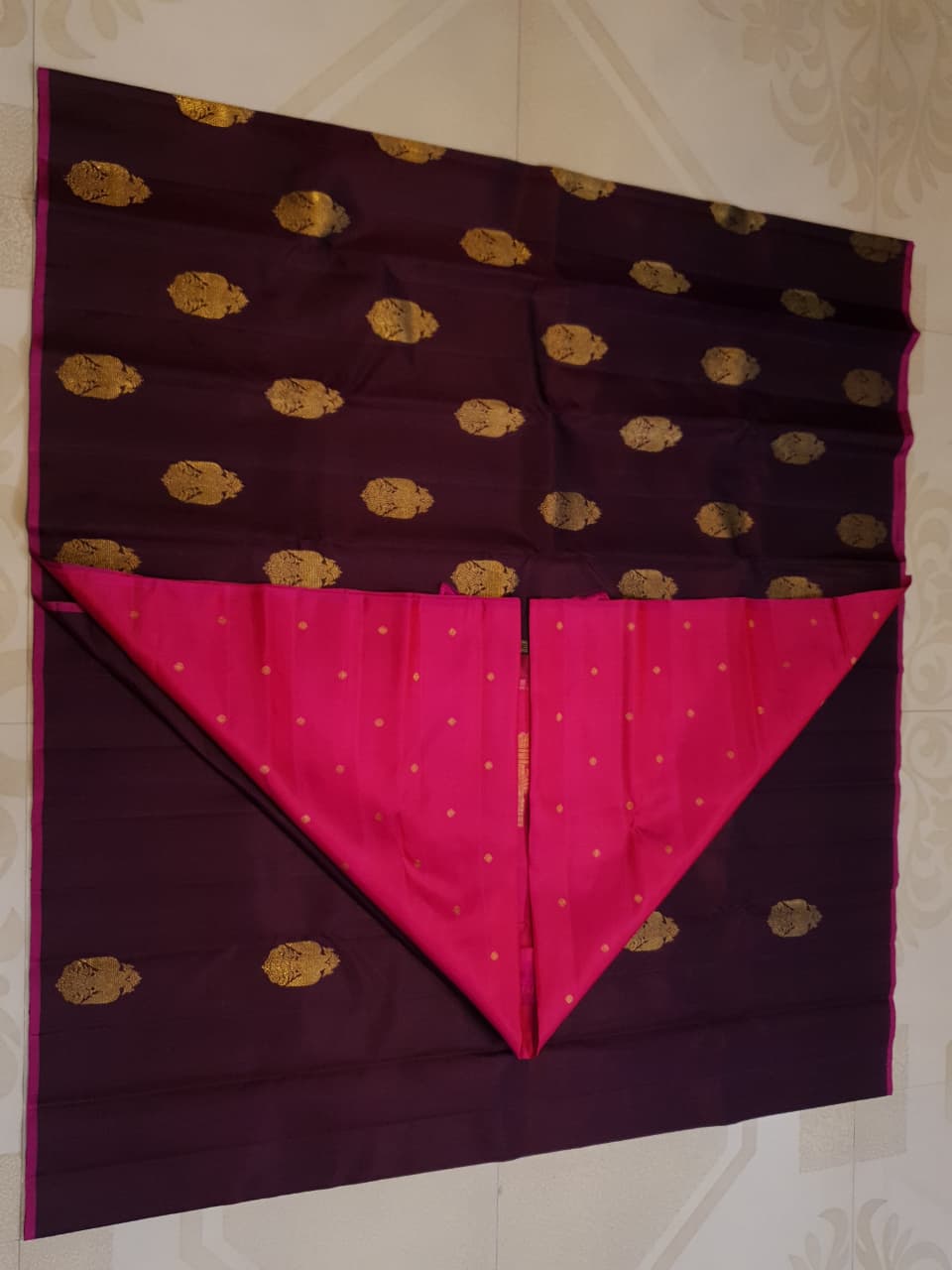 A certified magenta Kanchipuram handloom 3G pure gold borderless silk saree showcasing its rich color and lustrous weave.