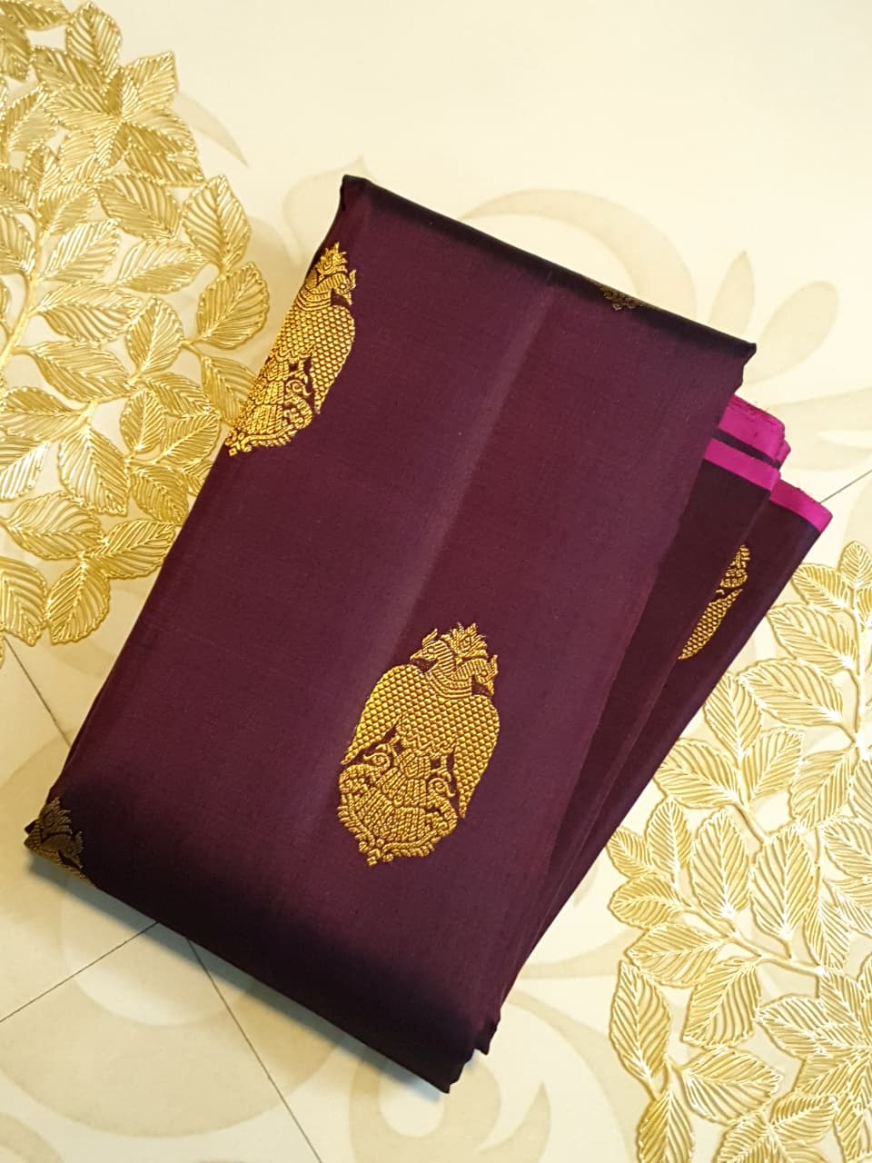 A certified magenta Kanchipuram handloom 3G pure gold borderless silk saree showcasing its rich color and lustrous weave.