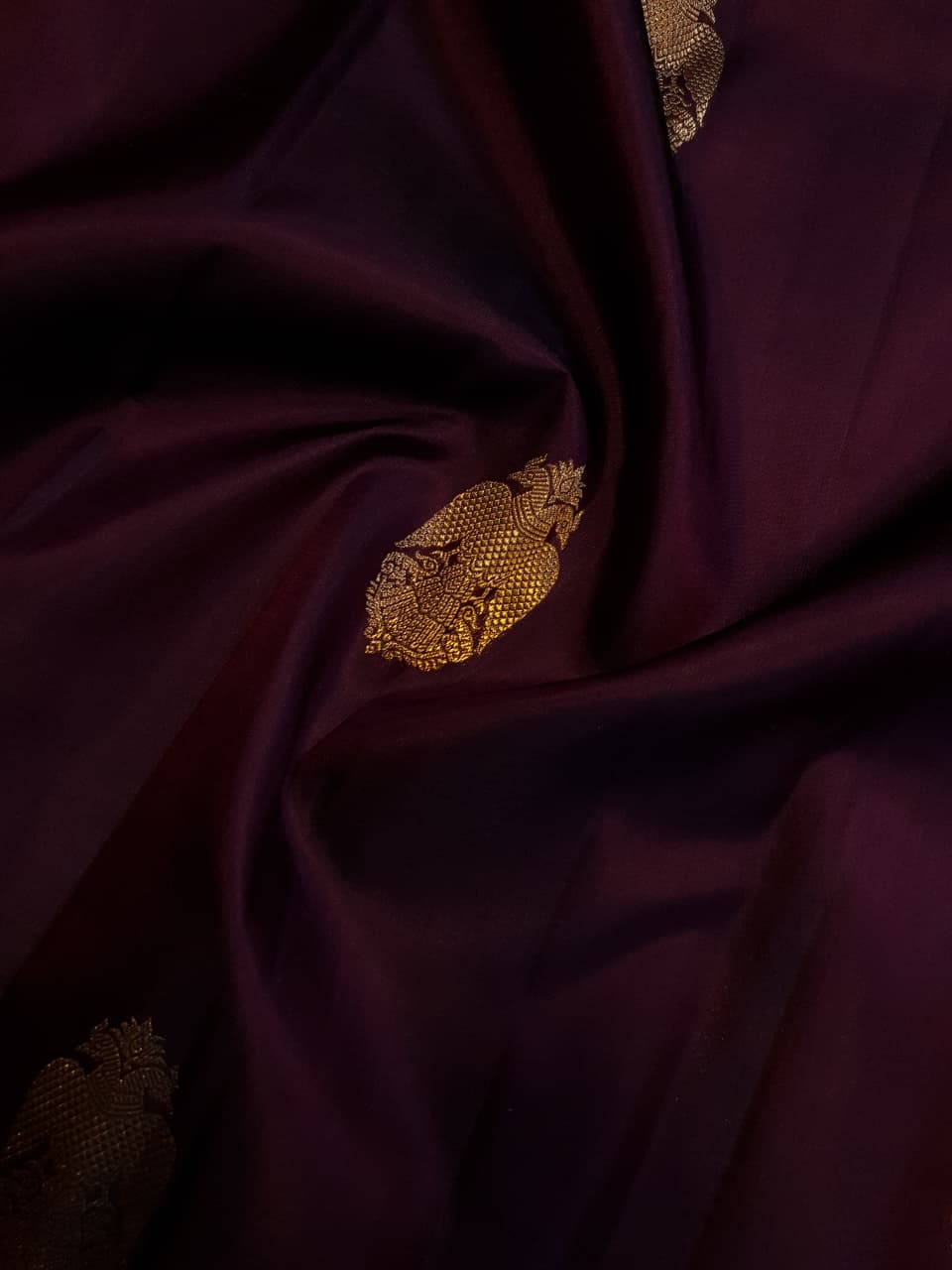 A certified magenta Kanchipuram handloom 3G pure gold borderless silk saree showcasing its rich color and lustrous weave.