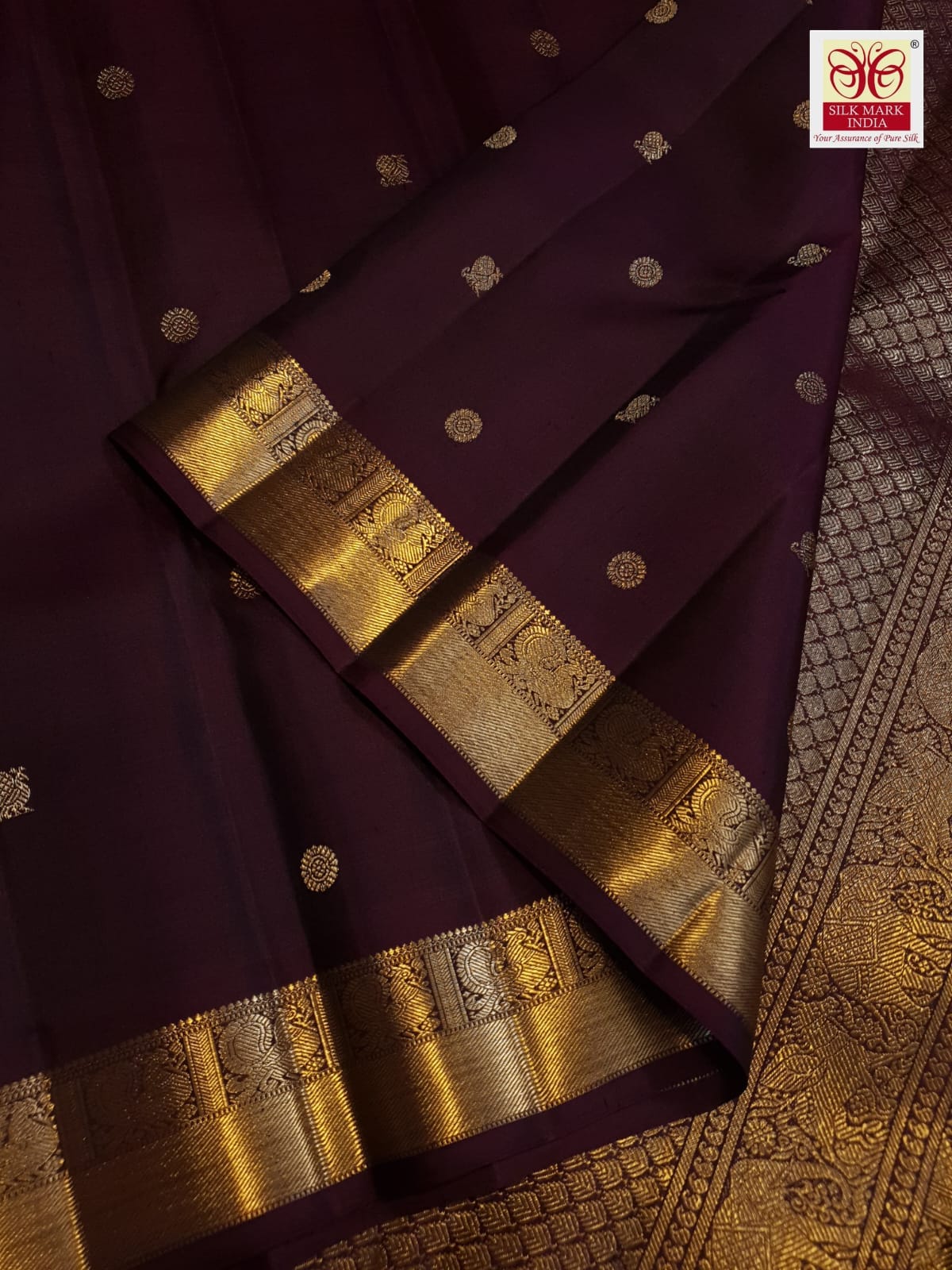 A deep purple Kanchipuram handloom 3G gold pattu silk saree adorned with intricate gold buttas and a rich traditional pallu.