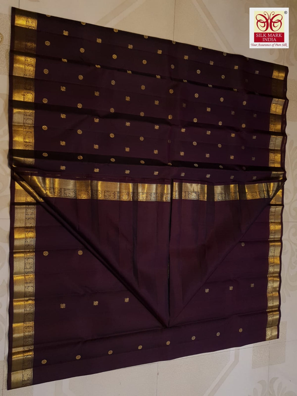 A deep purple Kanchipuram handloom 3G gold pattu silk saree adorned with intricate gold buttas and a rich traditional pallu.