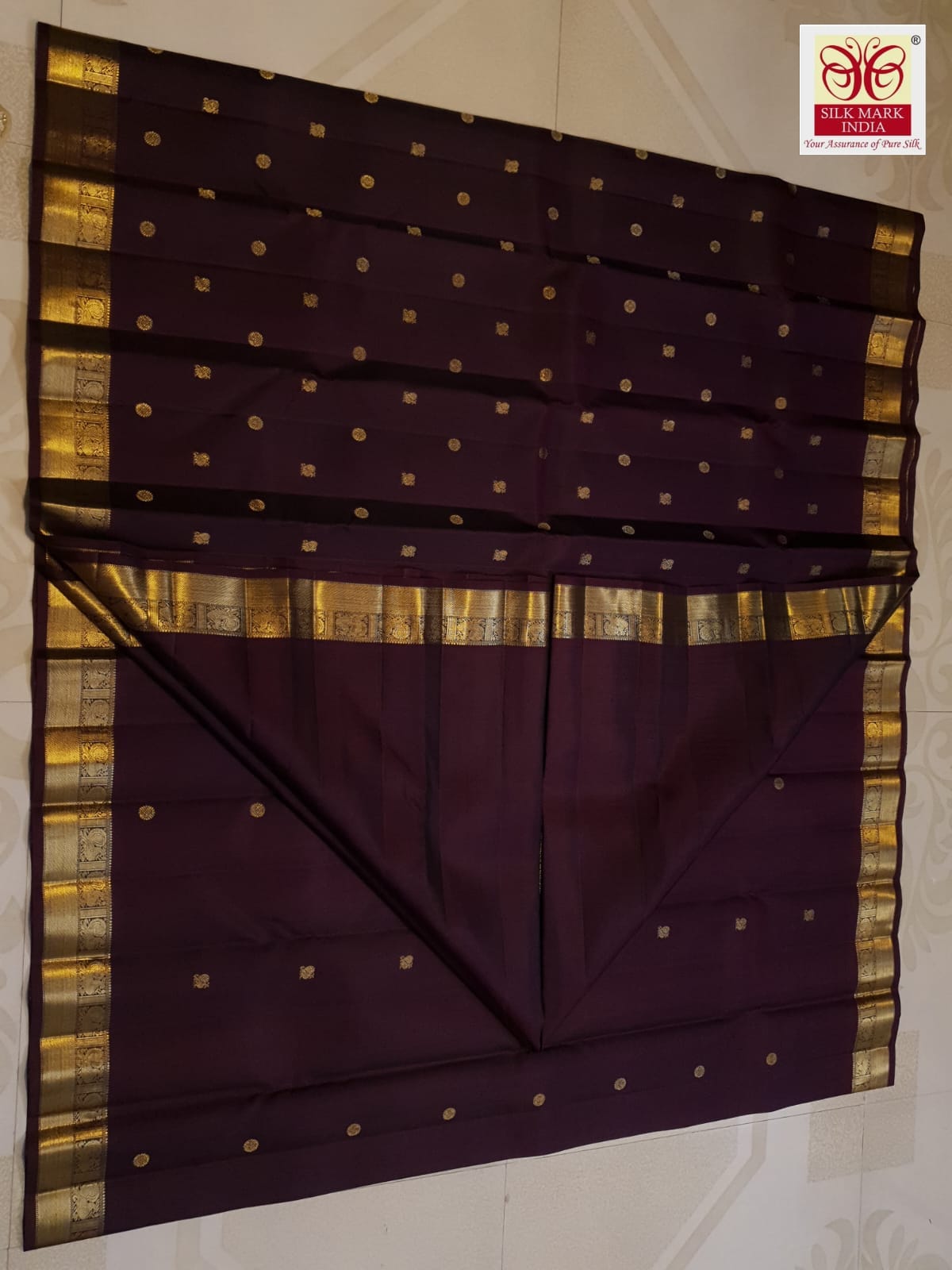 A deep purple Kanchipuram handloom 3G gold pattu silk saree adorned with intricate gold buttas and a rich traditional pallu.