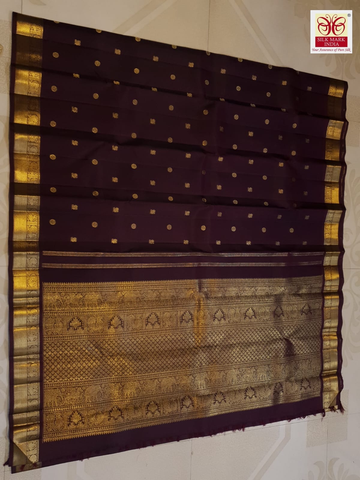 A deep purple Kanchipuram handloom 3G gold pattu silk saree adorned with intricate gold buttas and a rich traditional pallu.