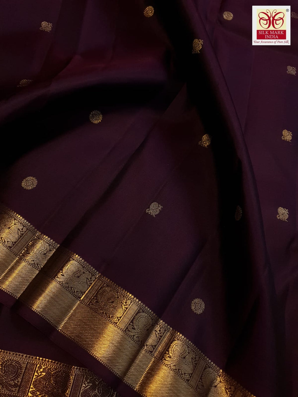 A deep purple Kanchipuram handloom 3G gold pattu silk saree adorned with intricate gold buttas and a rich traditional pallu.