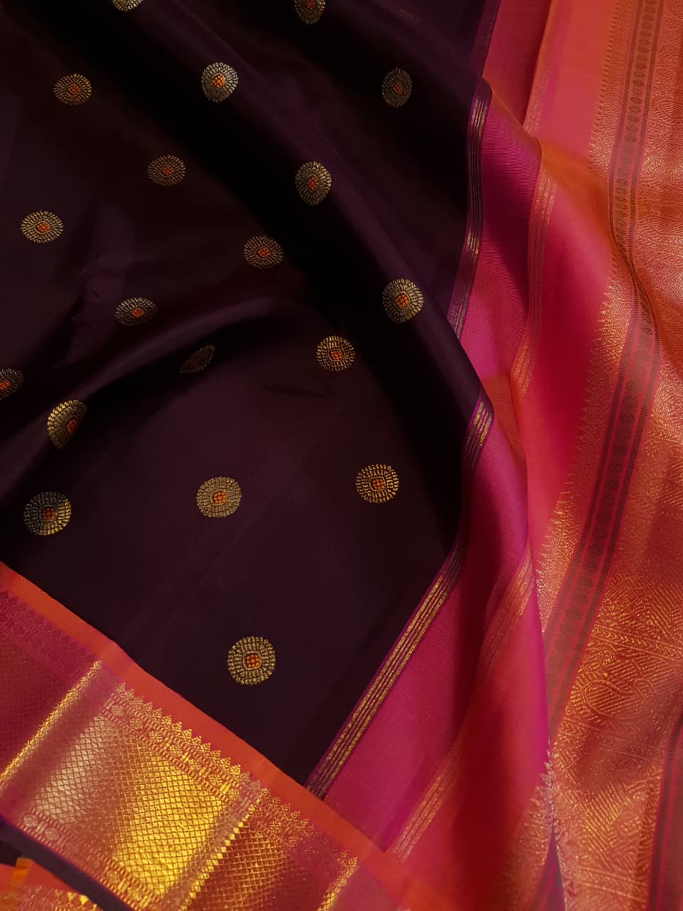 A rich brown Kanchipuram handloom 3G gold vintage korvai silk saree showcasing traditional contrasting borders and intricate motifs.