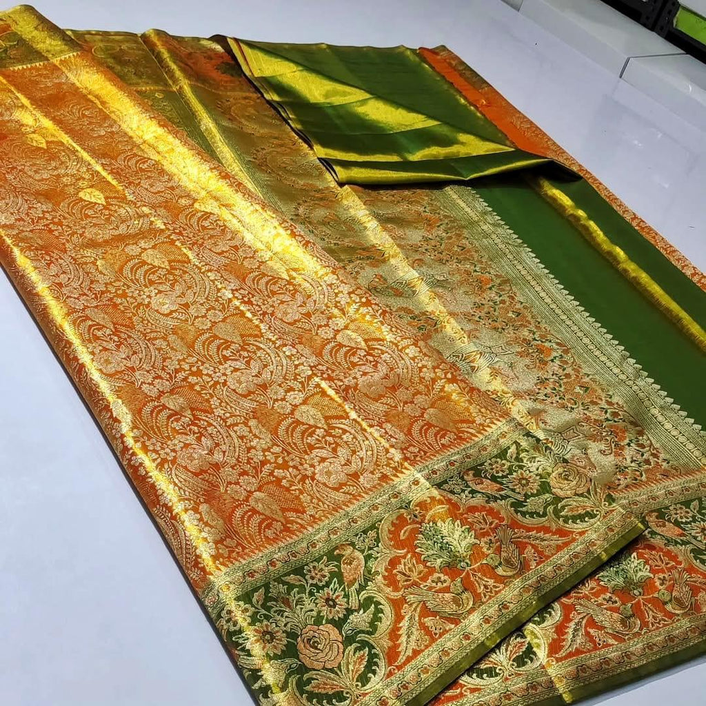 Dual-tone Orange and gold Kanchipuram tissue brocade silk saree featuring intricate Meenakari floral and bird motifs, styled with a contrasting olive green blouse in a traditional temple corridor.