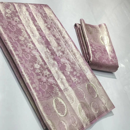 A close-up of an elegant baby pink Kanchipuram tissue silk saree with intricate gold brocade weaving, authentic Silk Mark certification, and a soft, lustrous metallic sheen.