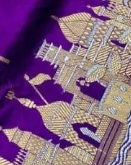 Royal purple Katan silk saree featuring gold zari Damru and Trishul motifs on the body and an intricate Kashi Ghat temple border.