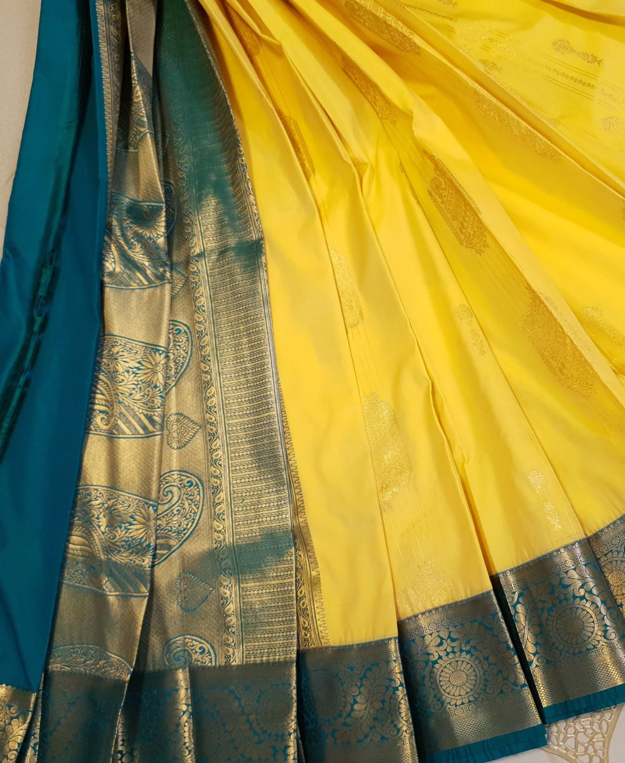 Lemon Yellow Kanchipuram Semi Pattu Silk Saree featuring a deep teal-green zari border with intricate floral and paisley motifs.