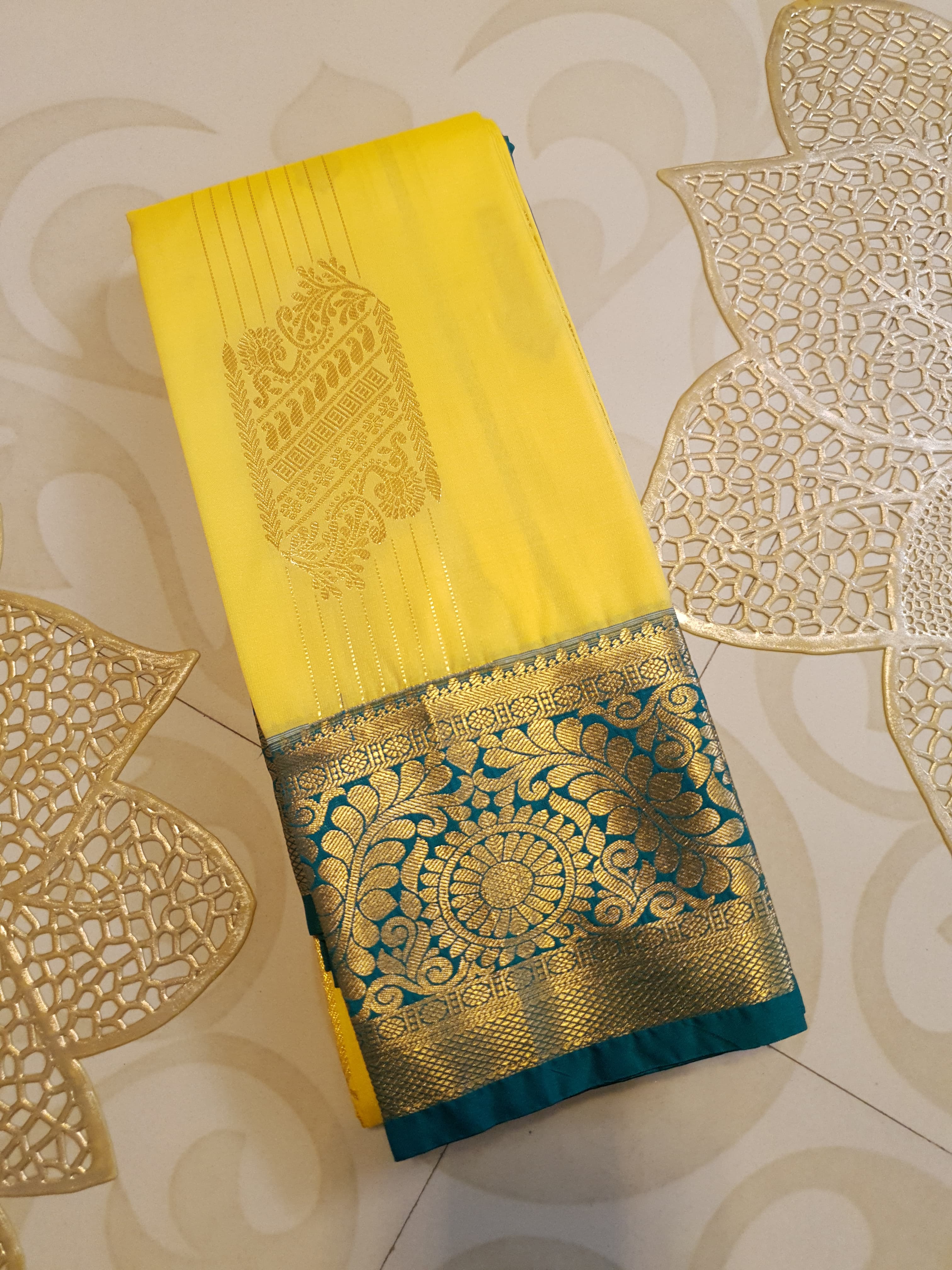 Lemon Yellow Kanchipuram Semi Pattu Silk Saree featuring a deep teal-green zari border with intricate floral and paisley motifs.