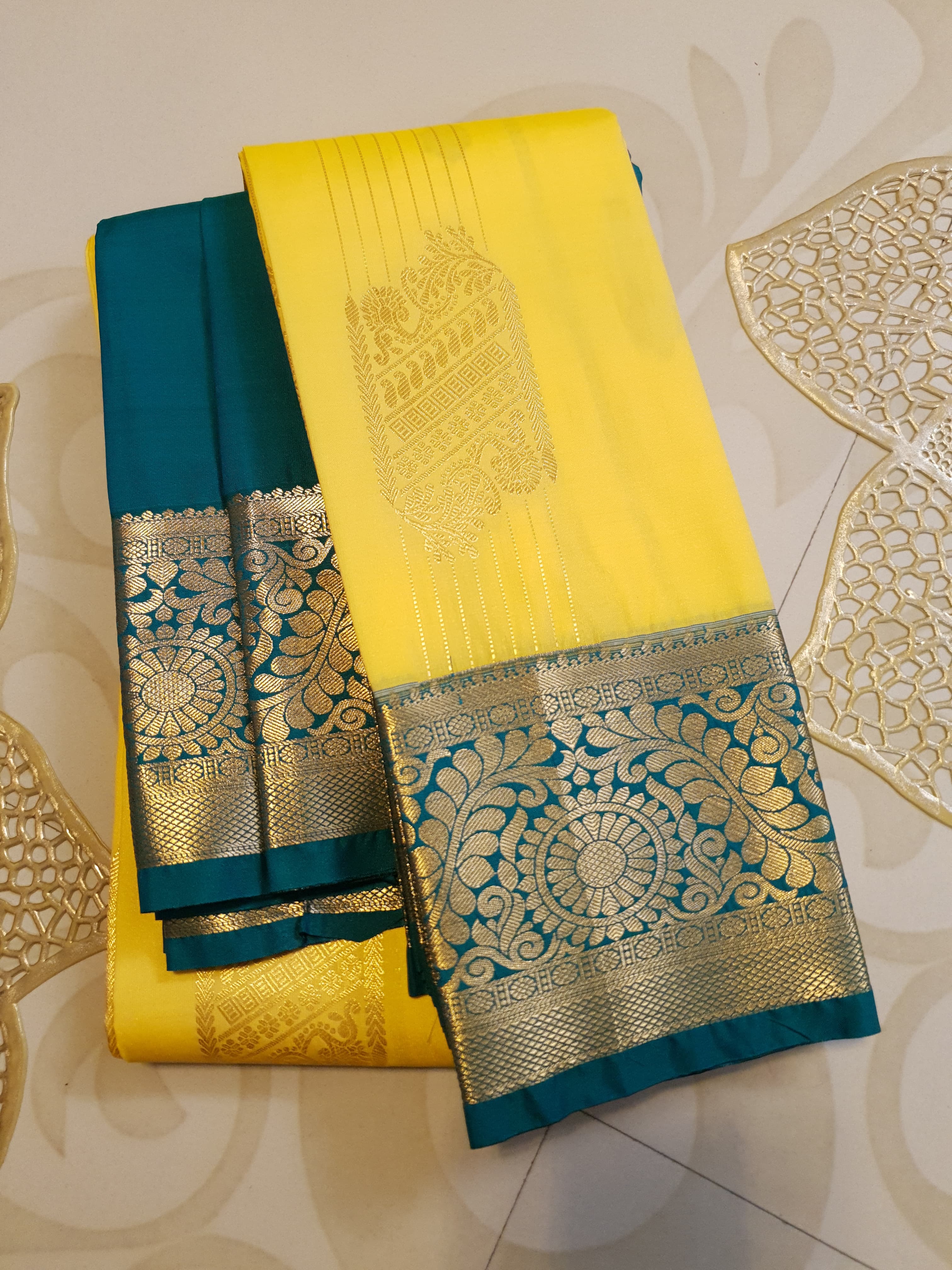 Lemon Yellow Kanchipuram Semi Pattu Silk Saree featuring a deep teal-green zari border with intricate floral and paisley motifs.