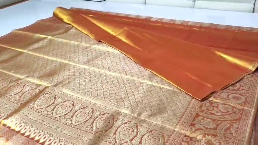 Copper Kanchipuram Handloom Tissue Brocade Silk Meenakari Saree displayed in a neat fold showcasing its rich gold zari and floral weave details.
