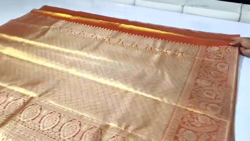 Copper Kanchipuram Handloom Tissue Brocade Silk Meenakari Saree displayed in a neat fold showcasing its rich gold zari and floral weave details.