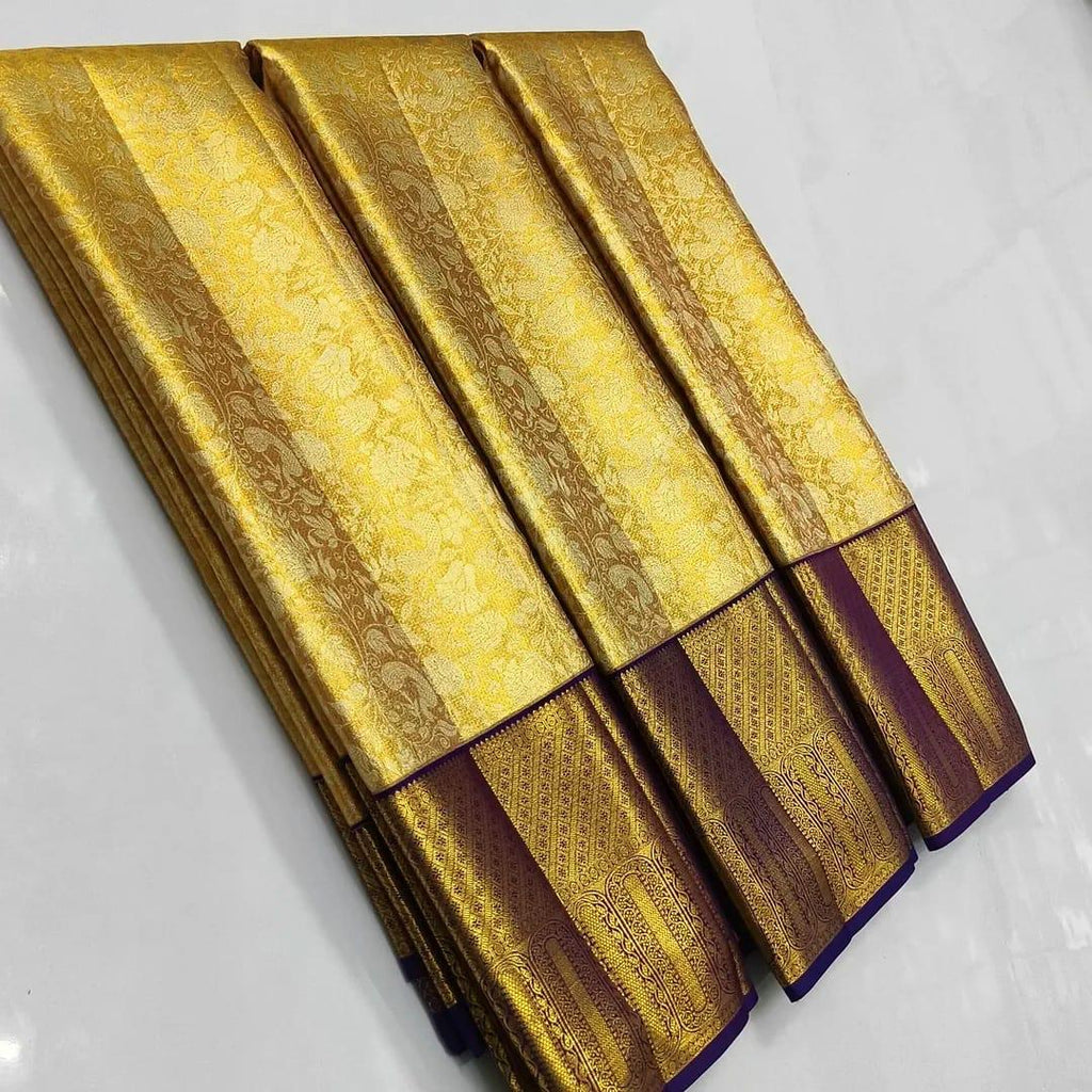 Gold Kanchipuram tissue brocade silk bridal saree with a rich violet border and intricate traditional zari pallu.