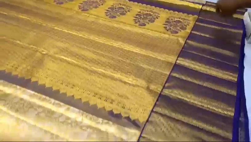 Gold Kanchipuram tissue brocade silk bridal saree with a rich violet border and intricate traditional zari pallu.