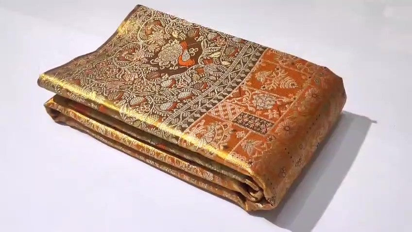 Orange Kanchipuram handloom 1G tissue silk saree with intricate meenakari brocade work and metallic zari borders, styled for a traditional South Indian wedding.