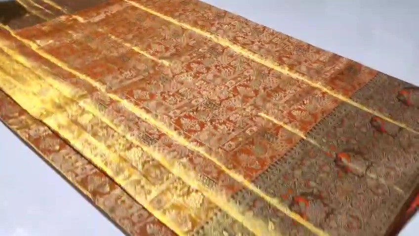 Orange Kanchipuram handloom 1G tissue silk saree with intricate meenakari brocade work and metallic zari borders, styled for a traditional South Indian wedding.