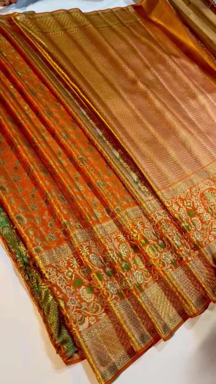 Orange Kanchipuram handloom double warp tissue brocade silk saree featuring intricate Meenakari floral patterns and a rich golden zari border.