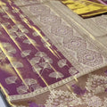 Plum Kanchipuram handloom tissue brocade silk saree with gold tissue sheen, intricate ginkgo leaf body motifs, and an antique gold border featuring floral motifs.