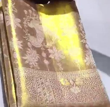 A close-up of a luxurious gold Kanchipuram tissue silk saree featuring intricate metallic brocade weaving, authentic Silk Mark certification, and a grand bridal luster.