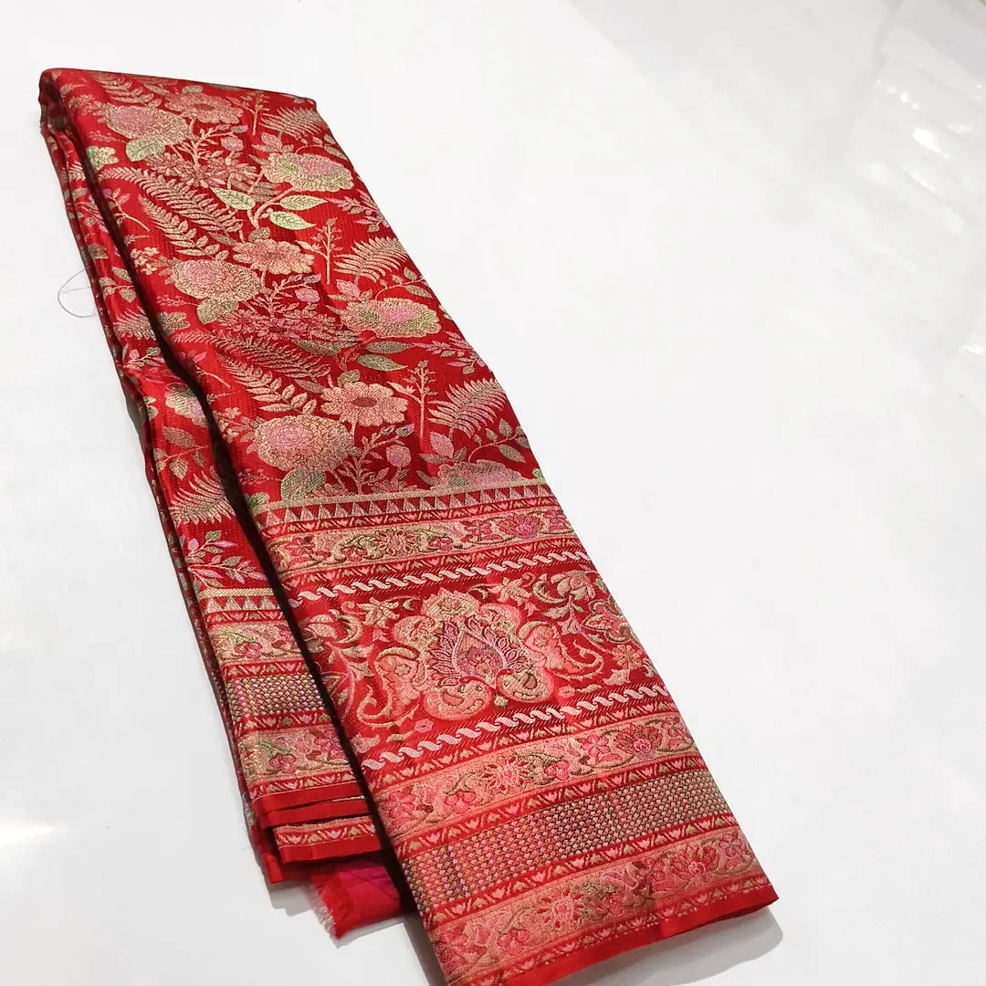 Classic red Kanchipuram handloom tissue brocade silk saree featuring intricate multicolored Meenakari weaving and shimmering pure zari work.