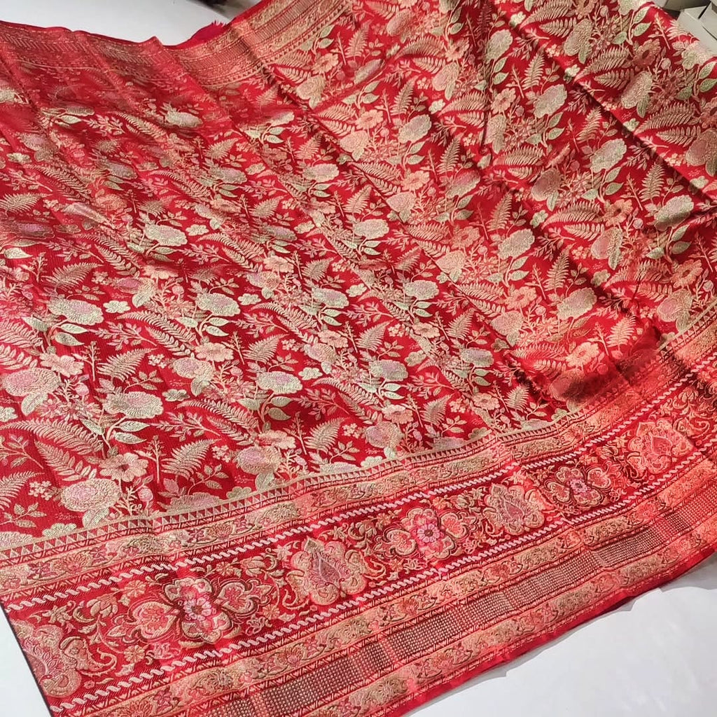 Classic red Kanchipuram handloom tissue brocade silk saree featuring intricate multicolored Meenakari weaving and shimmering pure zari work.