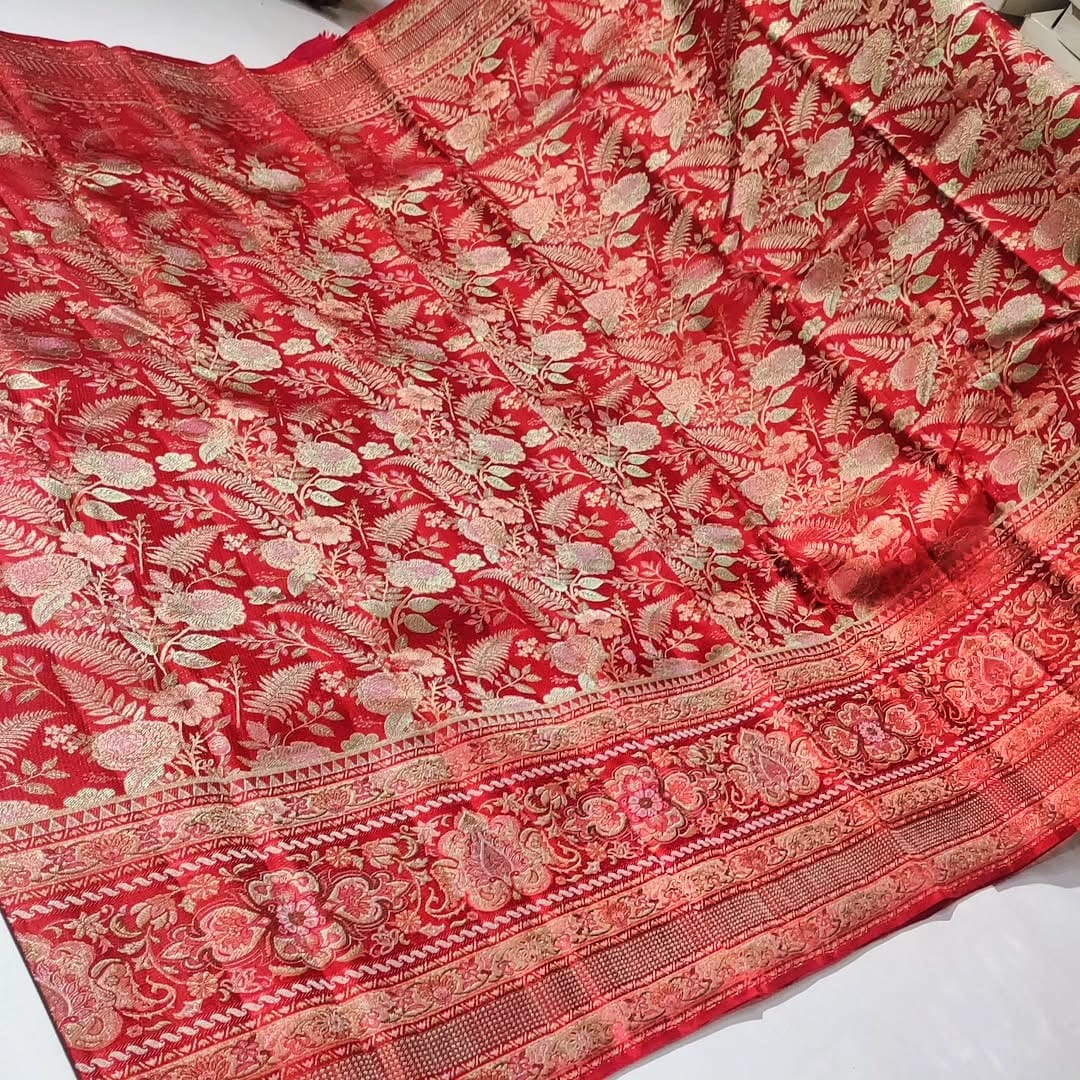 Classic red Kanchipuram handloom tissue brocade silk saree featuring intricate multicolored Meenakari weaving and shimmering pure zari work.