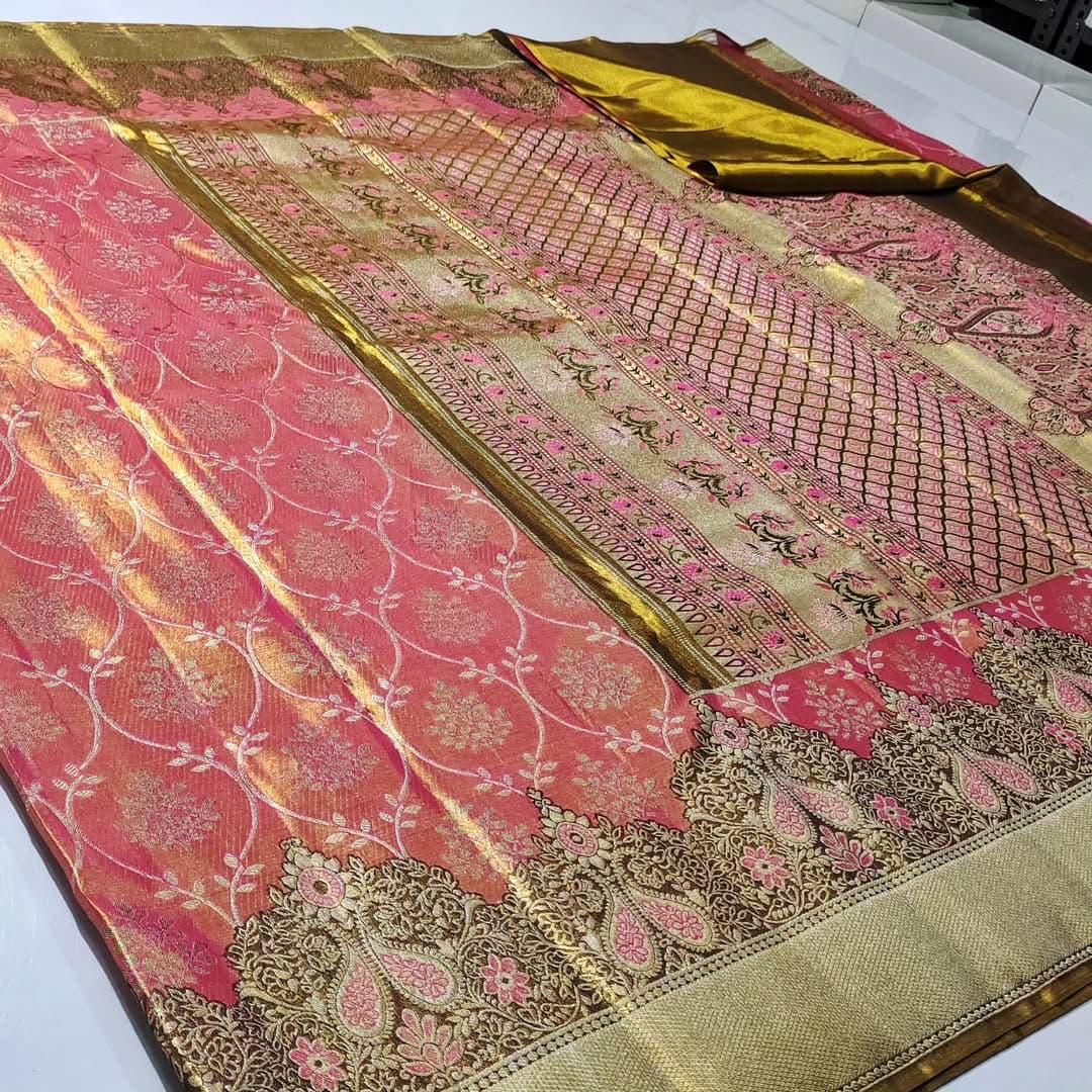 A luxurious Peach Pink Kanchipuram Handloom Tissue Silk Saree with all-over gold floral brocade and intricate colorful Meenakari detailing on the body and pallu.