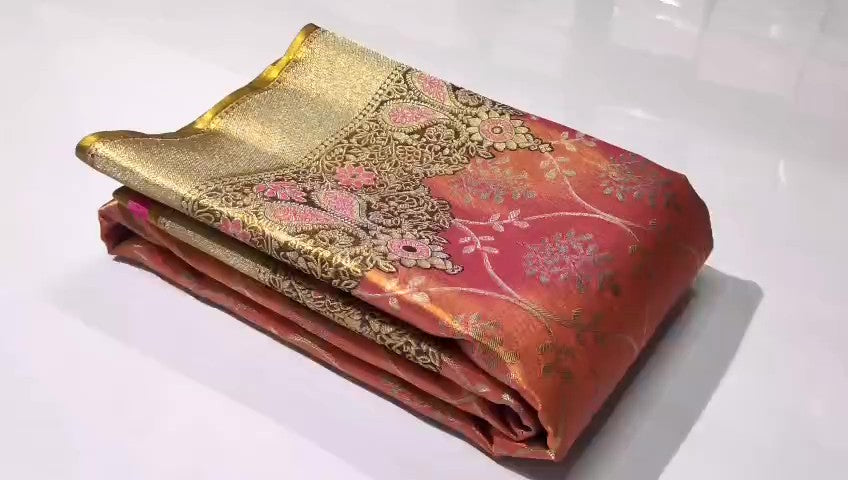 A luxurious Peach Pink Kanchipuram Handloom Tissue Silk Saree with all-over gold floral brocade and intricate colorful Meenakari detailing on the body and pallu.