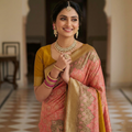 A luxurious Peach Pink Kanchipuram Handloom Tissue Silk Saree with all-over gold floral brocade and intricate colorful Meenakari detailing on the body and pallu.