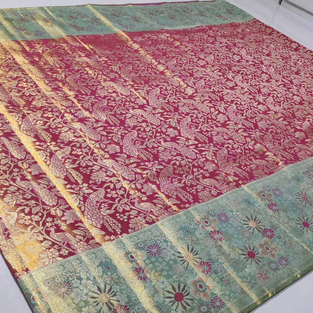 A vibrant Rani Pink Kanchipuram Handloom Tissue Silk Saree featuring a heavy gold tissue finish, all-over floral brocade, and colorful Meenakari accents.