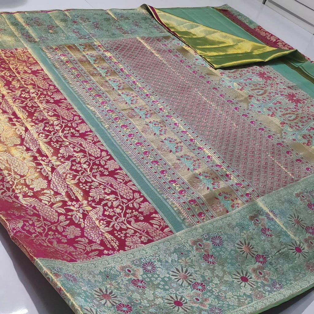 A vibrant Rani Pink Kanchipuram Handloom Tissue Silk Saree featuring a heavy gold tissue finish, all-over floral brocade, and colorful Meenakari accents.