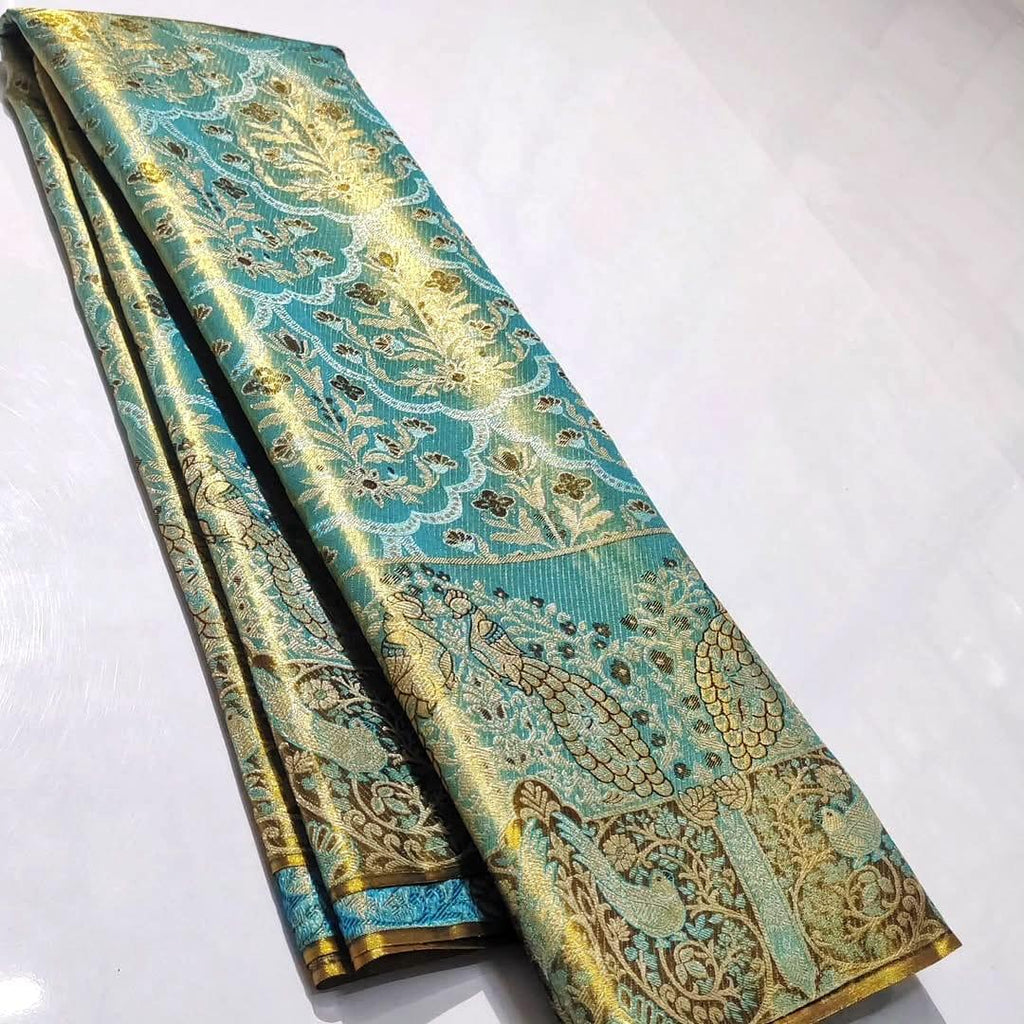 Radiant turquoise Kanchipuram handloom tissue brocade silk saree adorned with intricate multicolored Meenakari weaving and pure zari work.