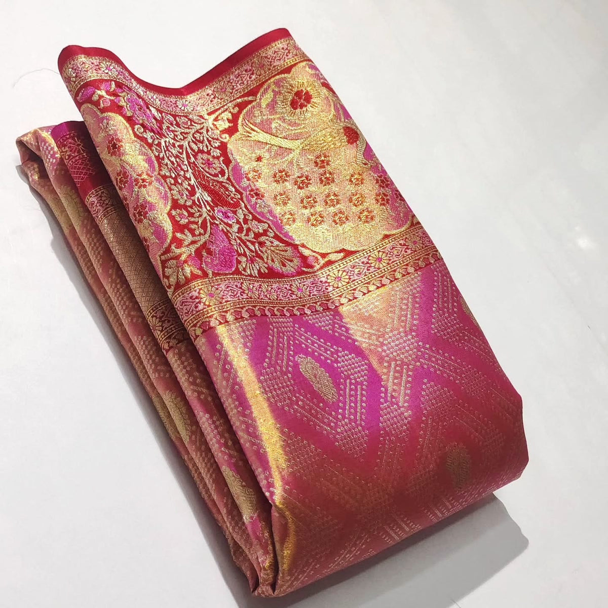 Rani Pink Kanchipuram handloom tissue brocade silk saree with intricate Meenakari floral patterns and a rich golden zari border.