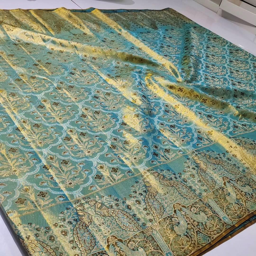 Radiant turquoise Kanchipuram handloom tissue brocade silk saree adorned with intricate multicolored Meenakari weaving and pure zari work.