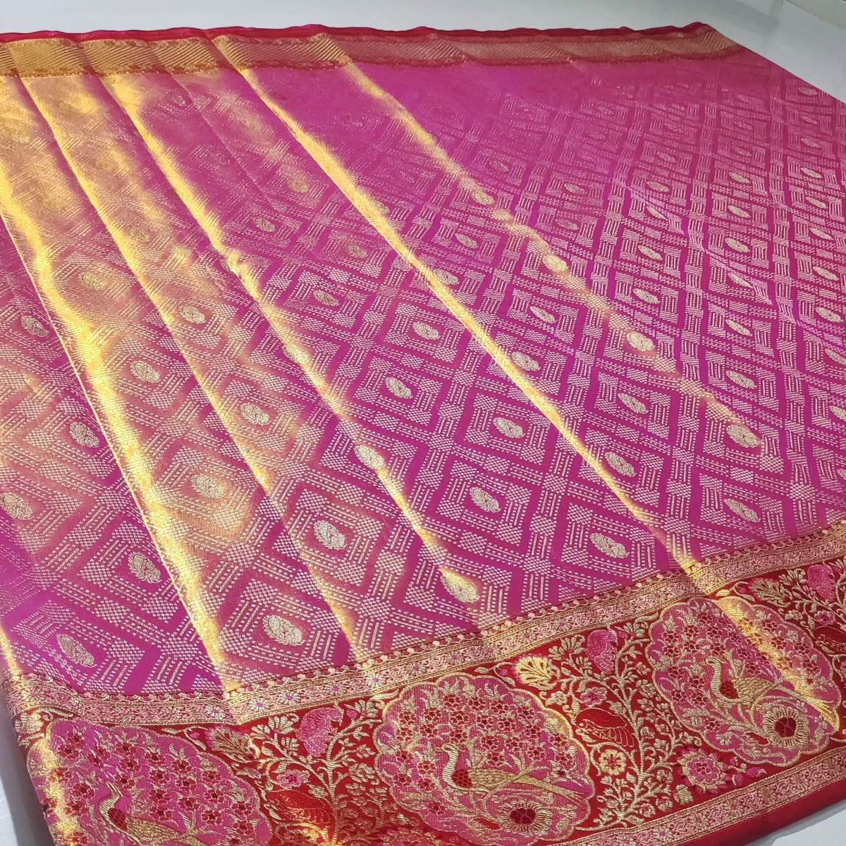 Rani Pink Kanchipuram handloom tissue brocade silk saree with intricate Meenakari floral patterns and a rich golden zari border.