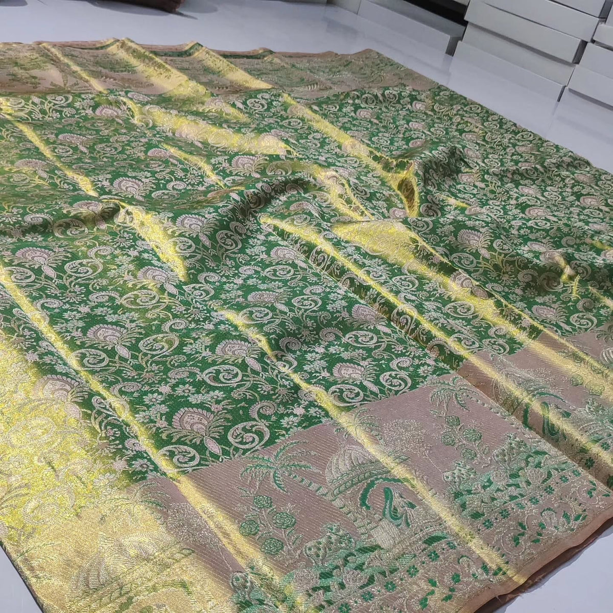Green Kanchipuram handloom tissue brocade silk saree with edge-to-edge Meenakari floral patterns and golden zari weaving.