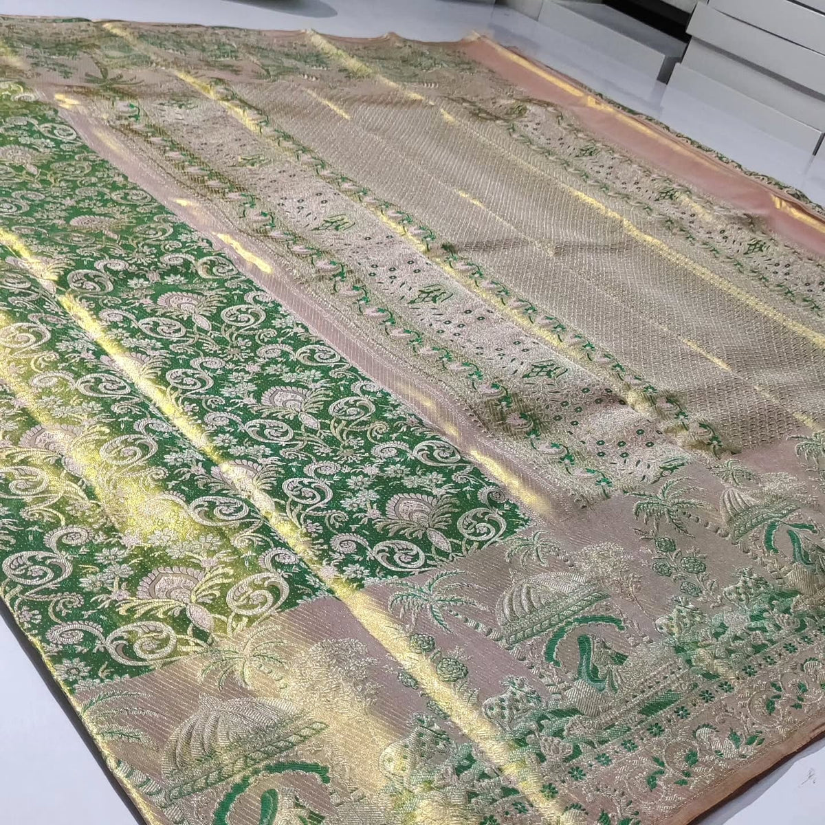 Green Kanchipuram handloom tissue brocade silk saree with edge-to-edge Meenakari floral patterns and golden zari weaving.