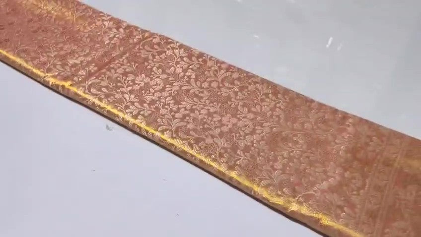 Peach Kanchipuram handloom tissue brocade silk bridal saree featuring an intricate all-over gold woven floral design and traditional zari borders.