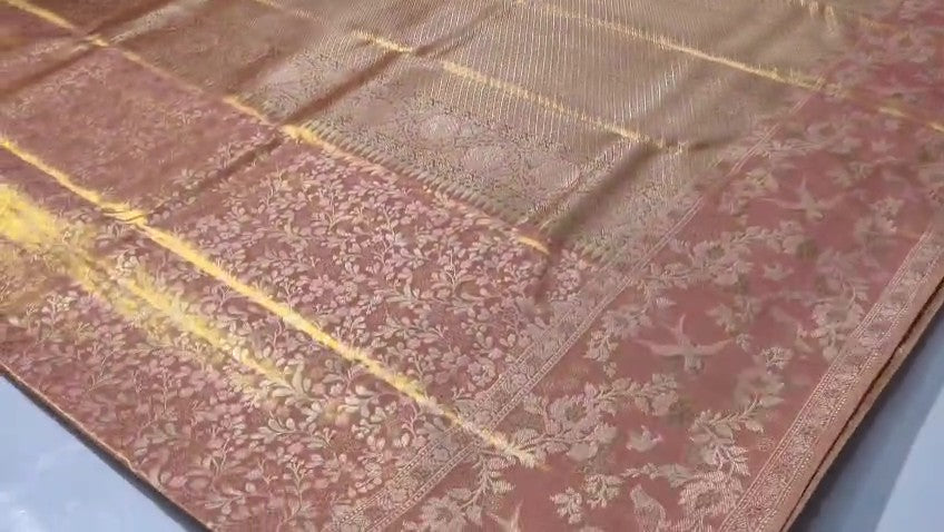 Peach Kanchipuram handloom tissue brocade silk bridal saree featuring an intricate all-over gold woven floral design and traditional zari borders.